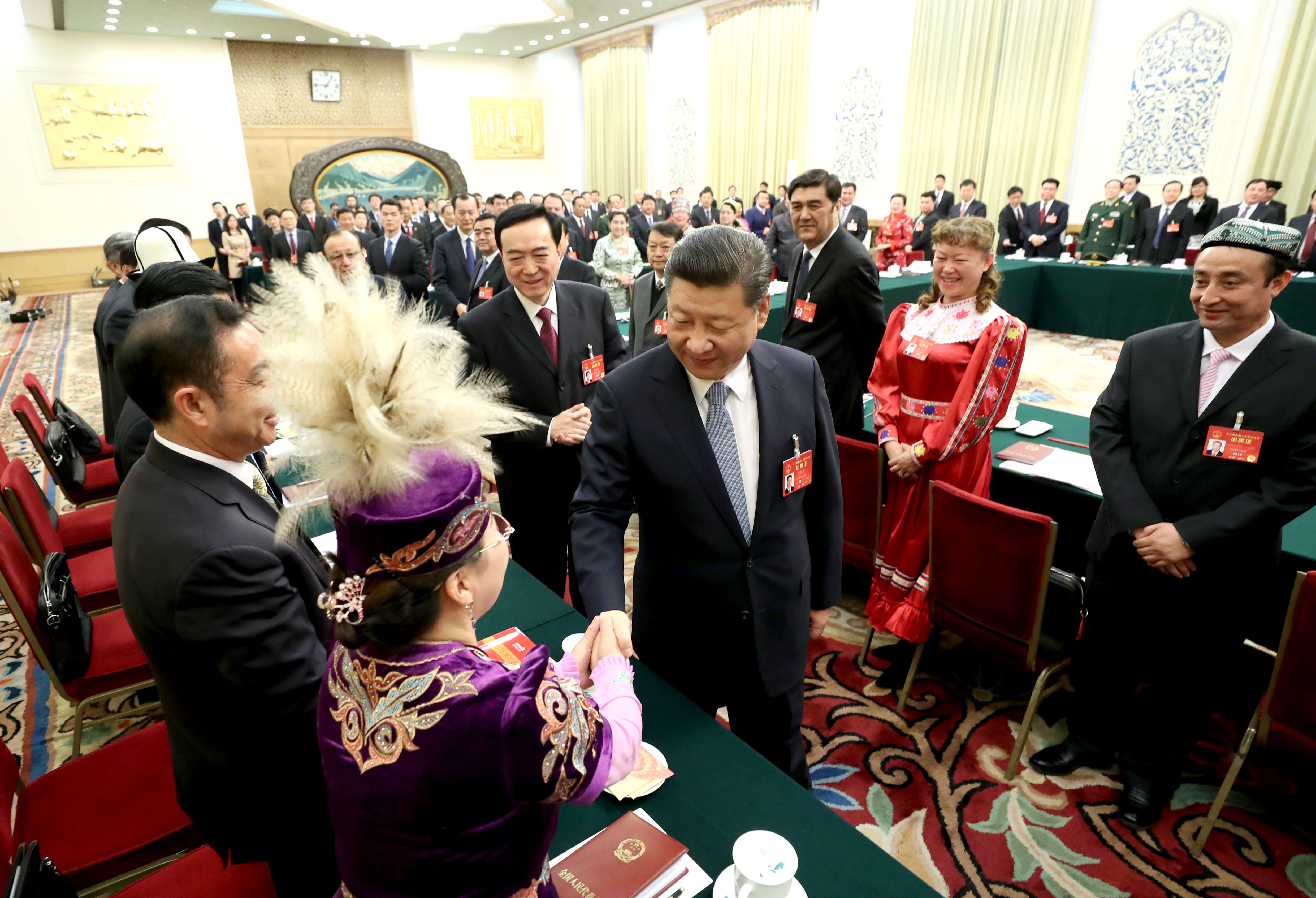 Chinese President Xi Jinping shakes hands with a national lawmaker from Xinjiang during a panel discussion at the ongoing annual session of the National People's Congress. [Photo: Xinhua/Lan Hongguang, Li Tao and Ma Zhancheng]