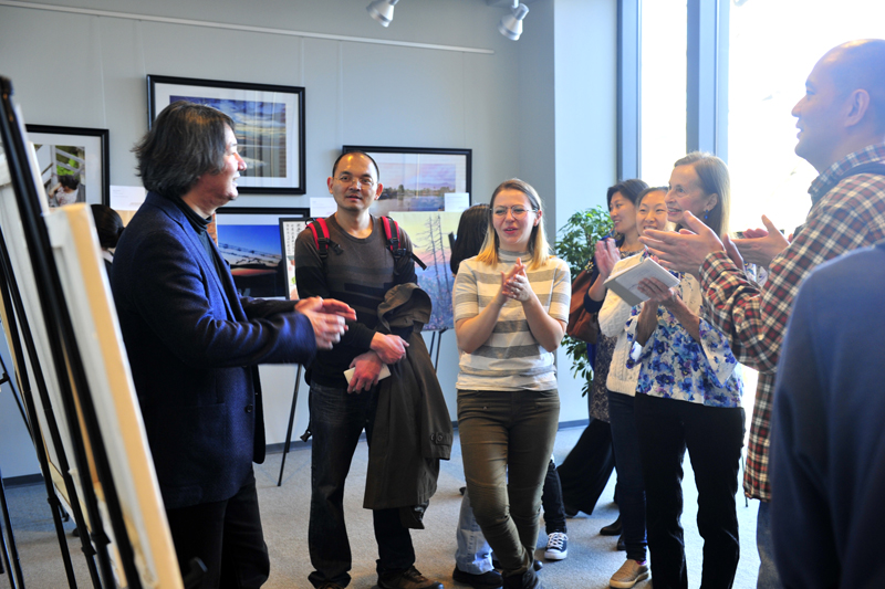 Yan Yu (Left) explains his painting to visitors in the Global Education Center of the University of North Caroline at Chapel Hill. [Photo provided for China Plus by Yu Jie]