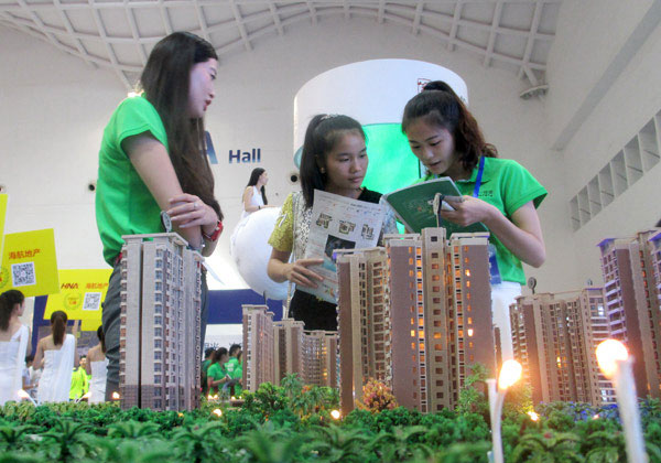 Saleswomen promote a property at a housing fair in Haikou, Hainan province. [Photo: China Daily]
