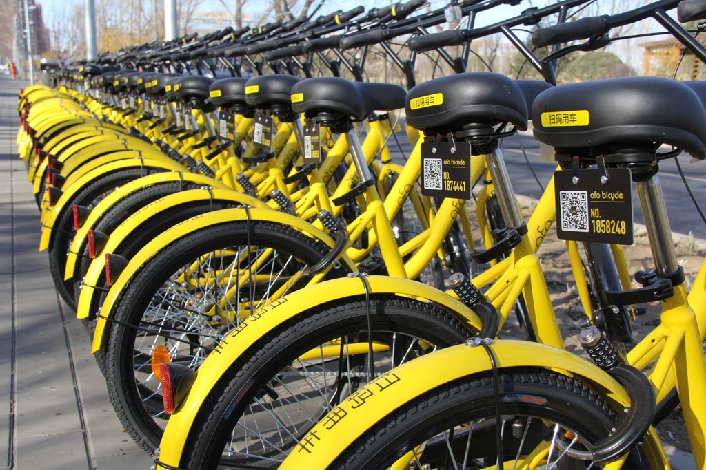 Bikes provided by Ofo, one of the leading bike-sharing companies, are spotted lining up along the street in Beijing, March 7, 2016. [Photo: China Plus/Huang Yue]