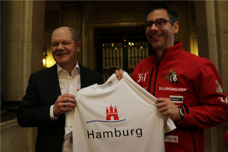 The 44-year-old runner Kai Markus (Right) and the Mayor of Hamburg, Olaf Scholz, pose for a photo at a farewell party in Hamburg, Germany, on March 9, 2017. [Photo: China Plus]