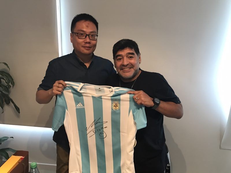 Diego Maradona gives a signed shirt to a China Radio International reporter in Buenos Aires, Argentina. [Photo: China Plus]