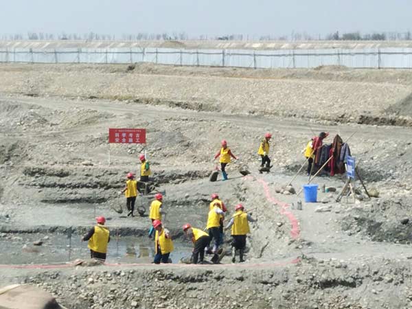 Workers excavate the Minjiang riverbed in the Pengshan district of Meishan, Sichuan province, on Monday trying to find relics from Zhang Xianzhong's sunken boats. [Photo by Huang Zhiling/chinadaily.com.cn]