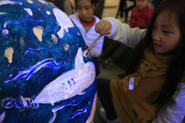 Kids draw pictures about environmental protection as Earth Hour is observed in Shanghai, on March 25, 2017. [Photo: thepaper.cn]