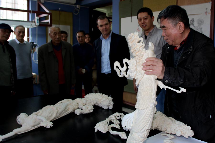 Managing director of the Beijing Ivory Carving Factory gives John Scanlon, Secretary-General of the Convention on International Trade in Endangered Species of Wild Flora and Fauna (CITES), a tour of the factory, March 31, 2017. [Photo: China Plus]