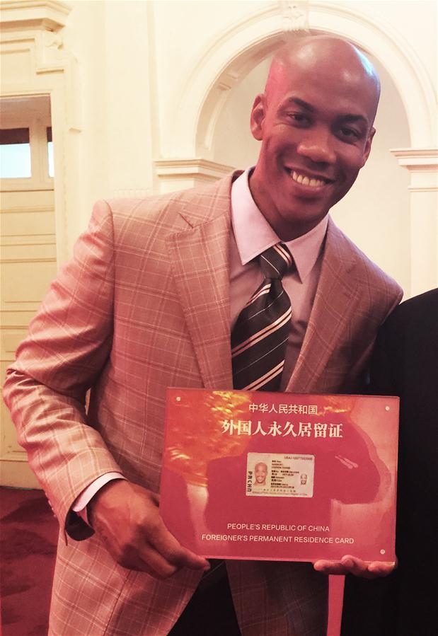 American basketball player, Stephon Marbury, shows his Chinese permanent residence card in Beijing on April 18, 2016. Marbury was the first foreign athlete to obtain a Chinese "green card". [File photo: Xinhua]