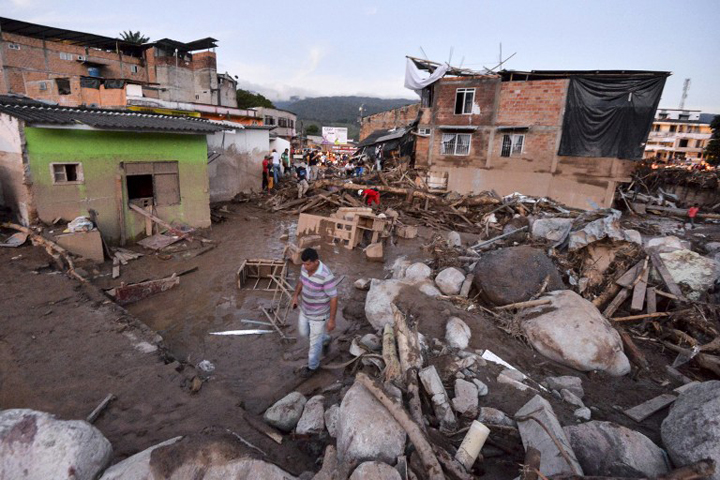 People walk through the rubble left by mudslides following heavy rains in Mocoa, Putumayo department, southern Colombia on April 1, 2017. [Photo: AFP]