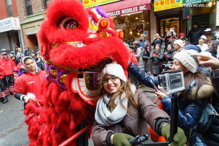 An American woman takes a selfie with someone in a lion costume in Manhattan's Chinatown in New York to celebrate Chinese Lunar New Year. [Photo: Xinhua]