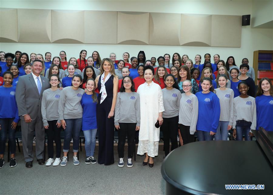 Peng Liyuan (7th R, Front), wife of Chinese President Xi Jinping, and U.S. First Lady Melania Trump (6th L, Front) pose with students during their visit to the Bak Middle School of the Arts in West Palm Beach, Florida, the United States, April 7, 2017. [Photo: Xinhua/Wang Ye]