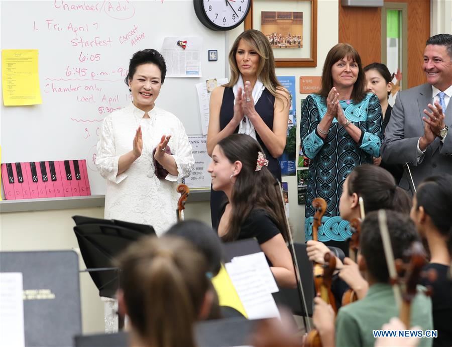 Peng Liyuan (1st L), wife of Chinese President Xi Jinping, and U.S. First Lady Melania Trump (2nd L), applaud to a performance by students during their visit to the Bak Middle School of the Arts in West Palm Beach, Florida, the United States, April 7, 2017. [Photo: Xinhua/Wang Ye]