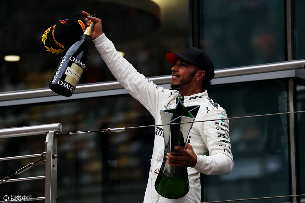 Race winner Lewis Hamilton celebrates on the podium at the Shanghai Audi International Circuit, on April 9, 2017. [Photo: VCG]