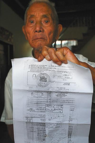 Li Guangdian shows tax documents for his temporary residential permit of Myanmar in Myitkyina, Myanmar, in April, 2017. [Photo: The Beijing News]