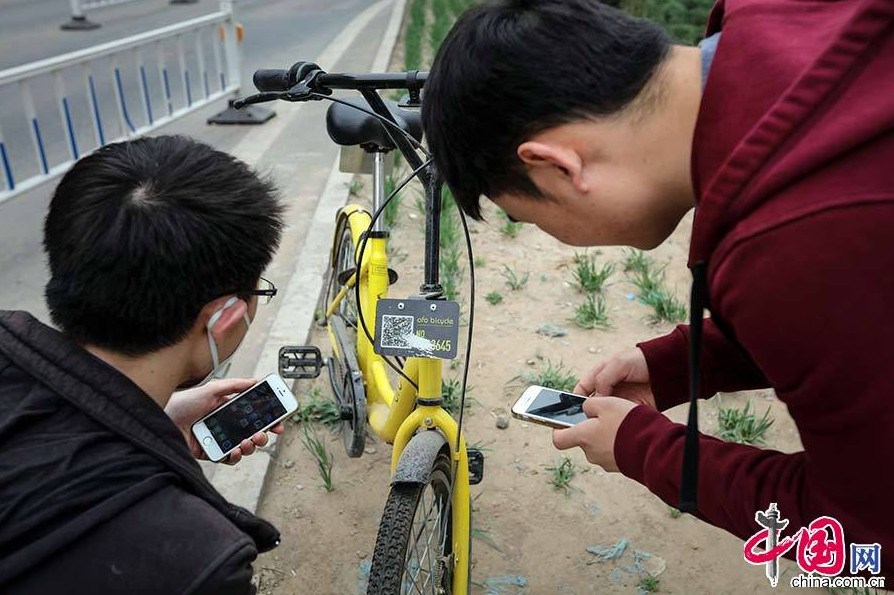 Yang Zhiqiang and another volunteer work on fixing damaged ofo bikes. [Photo: China.com.cn]