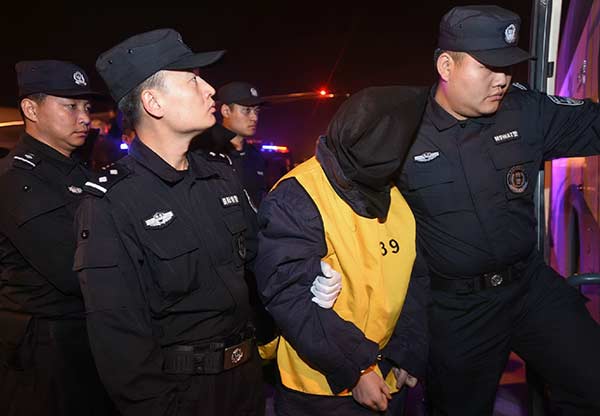Seventy-four suspects are brought back to Wuhan, Hubei province, in November after Chinese and Malaysian police cracked a telecom fraud case. [Photo: Xinhua]