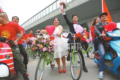A couple rides shared bikes as part of a wedding ceremony in Zhengzhou, capital of central China's Henan province, April 25, 2017. [Photo: dahe.cn]