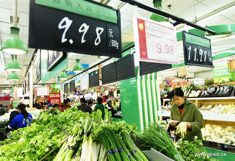 People select vegetables at a supermarket in Hangzhou, capital of east China's Zhejiang Province, Dec. 9, 2016. [Photo: Xinhua]
