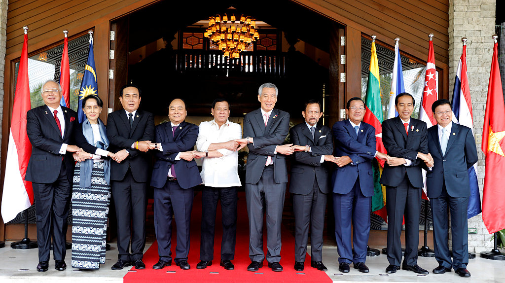 Southeast Asian leaders (L-R) Malaysian Prime Minister Najib Razak, Myanmar State Counsellor Aung San Suu Kyi, Thai Prime Minister Prayuth Chan-ocha, Vietnamese Prime Minister Nguyen Xuan Phuc, Philippine President Rodrigo Duterte, Singapore Prime Minister Lee Hsien Loong, Sultan Hassanal Bolkiah of Brunei Darussalam, Cambodian Prime Minister Hun Sen, Indonesian President Joko Widodo and Lao Prime Minister Thongloun Sisoulith link arms as they pose for a family photo during the 30th Association of Southeast Asian Nations (ASEAN) summit in Manila, Philippines April 29, 2017. [Photo: VCG/Erik De Castro]
