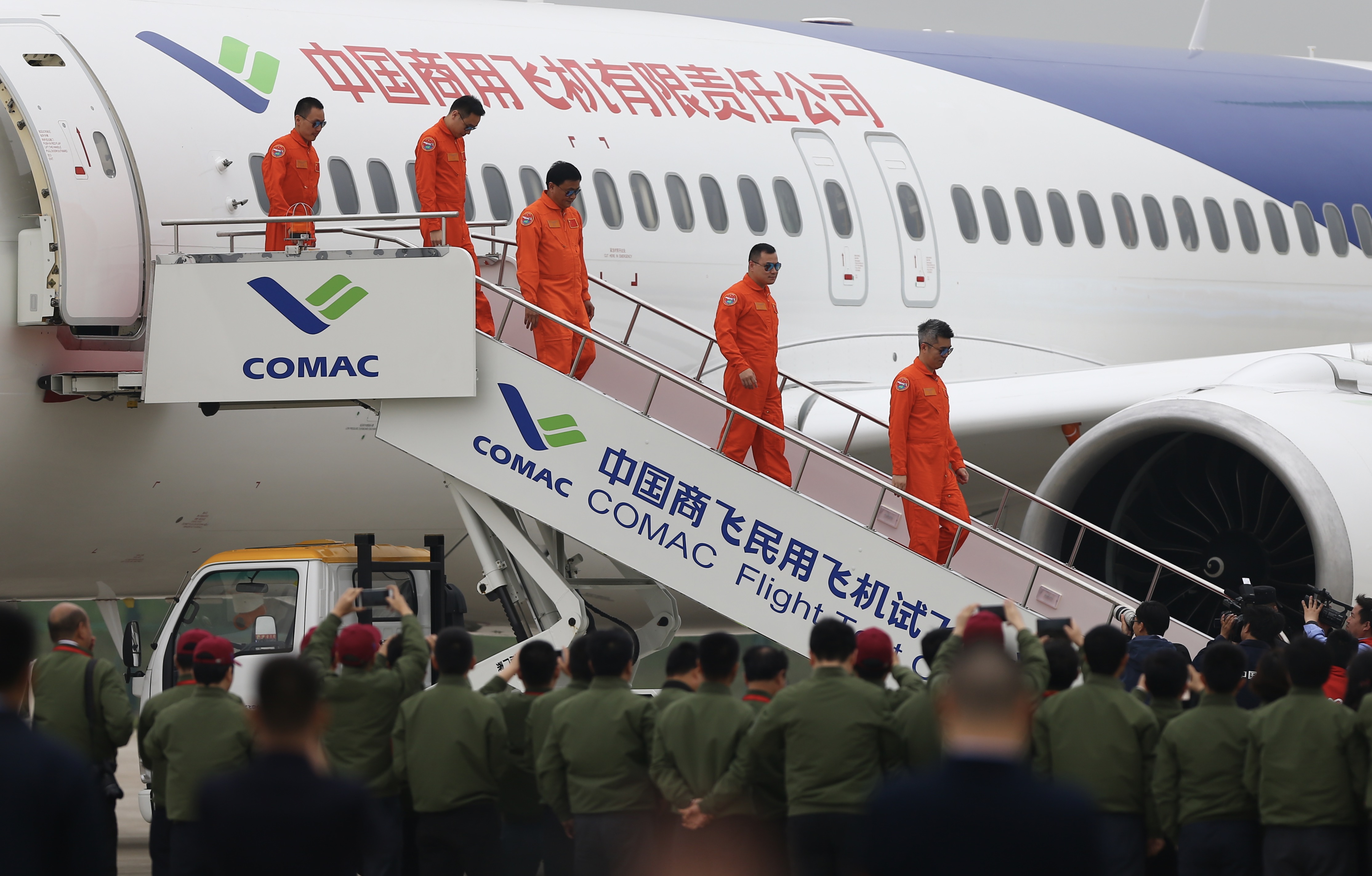 Five test pilots walk down the stairs of C919 after successfully completing the maiden flight of the Chinese-built airplane. [Photo: China Plus/ Li Jin] 