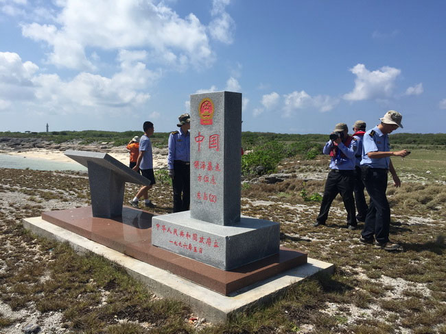 Chinese marine law enforcement personnel check a patrol point monument marking Chinese territorial waters on one of the Xisha islands in the South China Sea, in April 2017. [Photo: scsb.gov.cn]