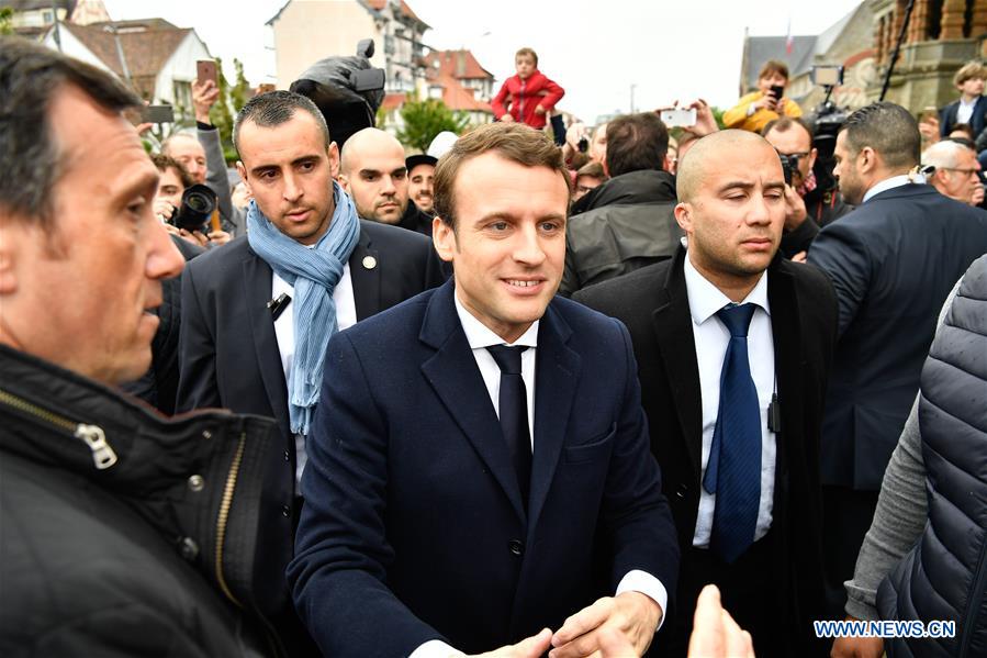 Emmanuel Macron (C) arrives to cast his ballot in the second round of the presidential election in Le Touquet, France, May 7, 2017. [Photo: Xinhua]