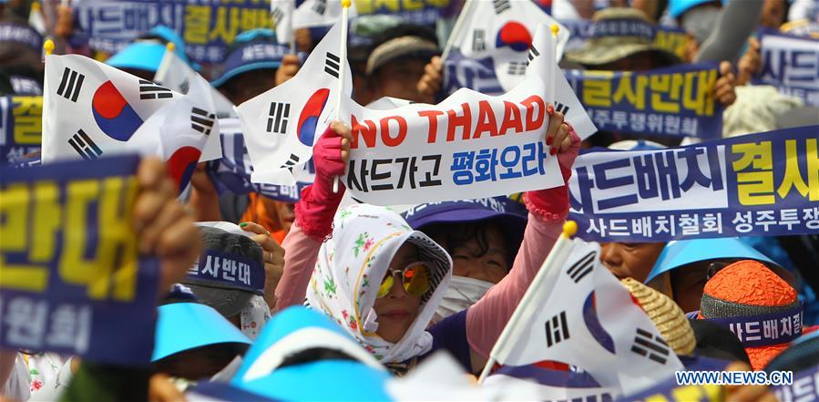People from Seongju county hold the national flags of South Korea and banners to protest against the deployment of the Terminal High Altitude Area Defense (THAAD), during a rally in Seoul, capital of South Korea, on July 21, 2016. More than 2,000 people from Seongju county, where one THAAD battery will be deployed, gathered at a square in Seoul for a rally on Thursday, to protest against the deployment of THAAD. [Photo: Xinhua/Yao Qilin]