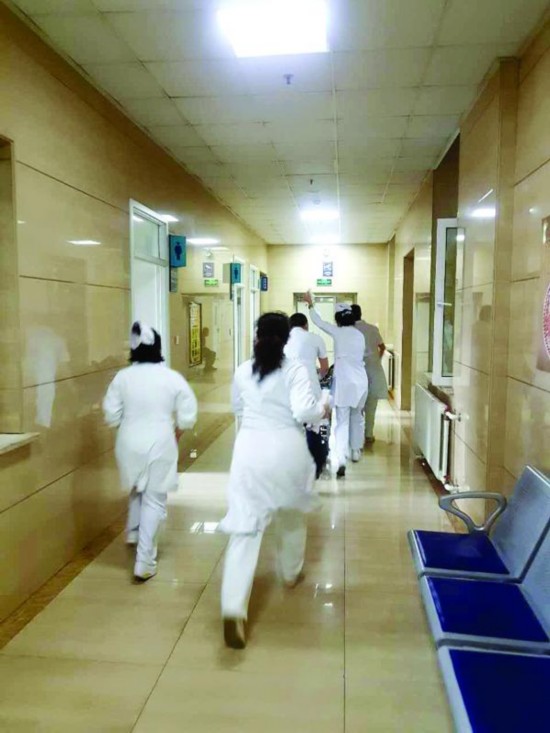 Doctors and nurses rush to an emergency room at Harbin No.2 Hospital to try to revive heart attack victim. [Photo: hljnews.cn]