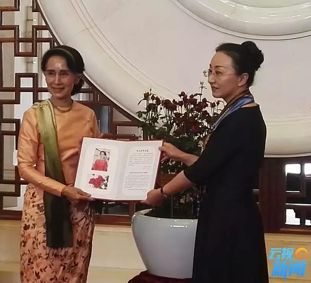 Myanmar State Counsellor Aung San Suu Kyi (L) accepts a commemorative document for the new rose species named in her honor in Kunming, capital of southwest China's Yunnan province, May 17, 2017. [Photo: ynradio.com]
