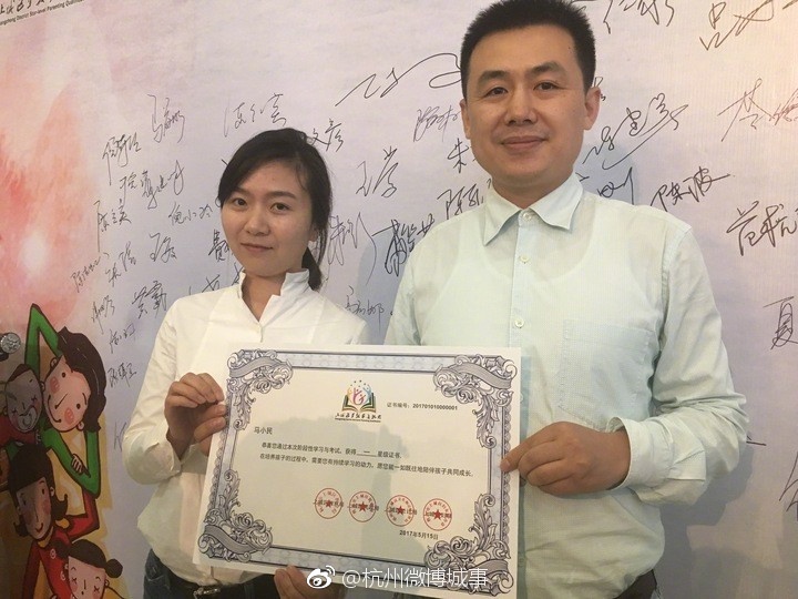 Ma Xiaomin (R), a father of two, receives China's first parent's license in Hangzhou on Tuesday, May 16, 2017. [Photo: Weibo]
