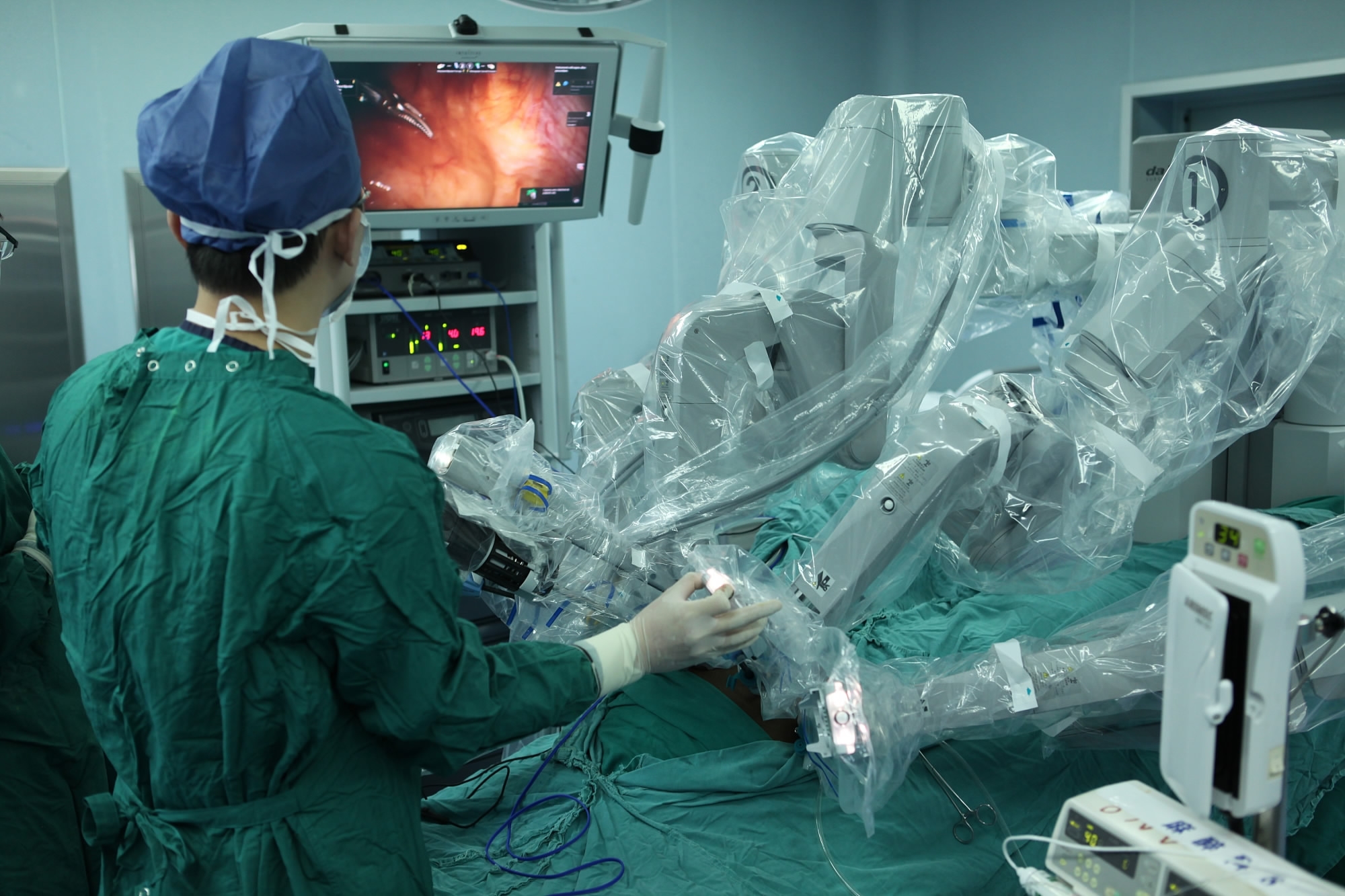 A surgeon is helping adjust robotic arms of da Vinci System. [Photo: VCG]