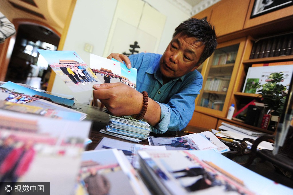Gao Yuan displays unclaimed photos he has taken through the years at his home in Beijing on Tuesday, May 23, 2017. [Photo: the Beijing News]
