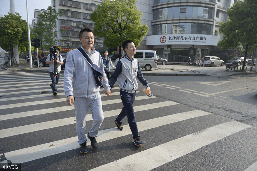 LGBT couple Sun Wenlin and his partner appear before the case heard in Changsha, central China's Hunan province on April 13, 2016. [Photo: vcg.com]