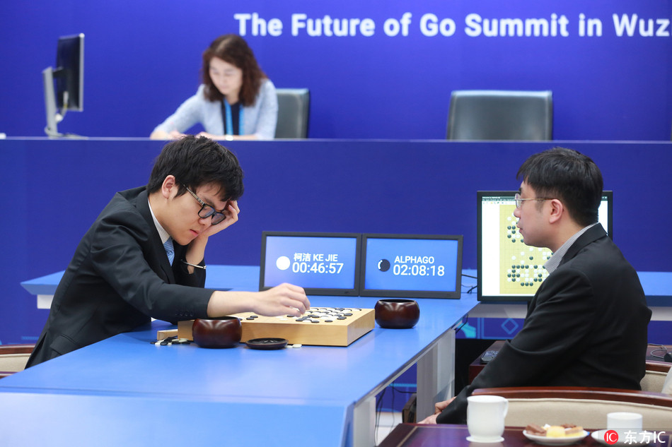 Chinese Go player Ke Jie, left, competes against Google's artificial intelligence (AI) program, AlphaGo, as Google DeepMind's lead programmer Aja Huang sits in the second game of the Google DeepMind Challenge Match during the Future of Go Summit in Wuzhen town, Jiaxing city, east China's Zhejiang province, 25 May 2017. [Photo: IC]