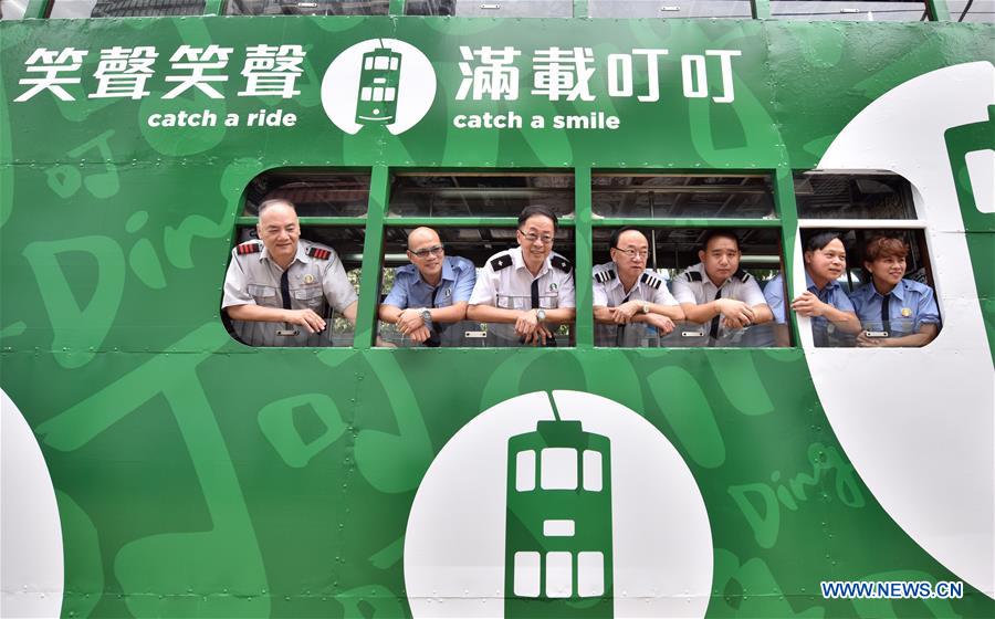 Staff members pose for a photo in a newly-decorated tram in Hong Kong, south China, May 26, 2017. [Photo: Xinhua/Wang Xi]