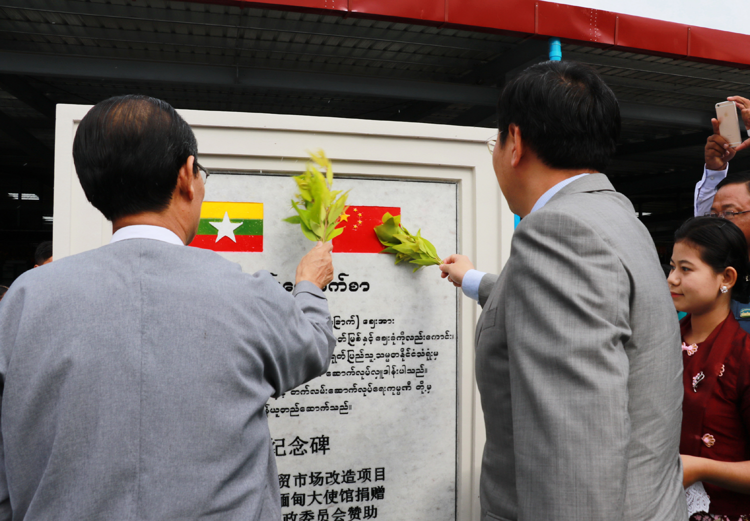 Chinese Ambassador to Myanmar, Hong Liang, and Chairman of Nay Pyi Taw Council, Dr. Myo Aung, reveal a stone monument for the rebuilt Thapyaygone Market on May 27, 2017. [Photo: China Plus/Tu Yun]