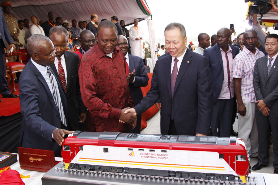 Kenyan President Uhuru Kenyatta 2nd left, and Chen Fenjian president of CCC shaking hands next to a model of a locomotive in Mombasa, Kenya, Tuesday, May 30, 2017. [Photo: AP /Khalil Senosi]