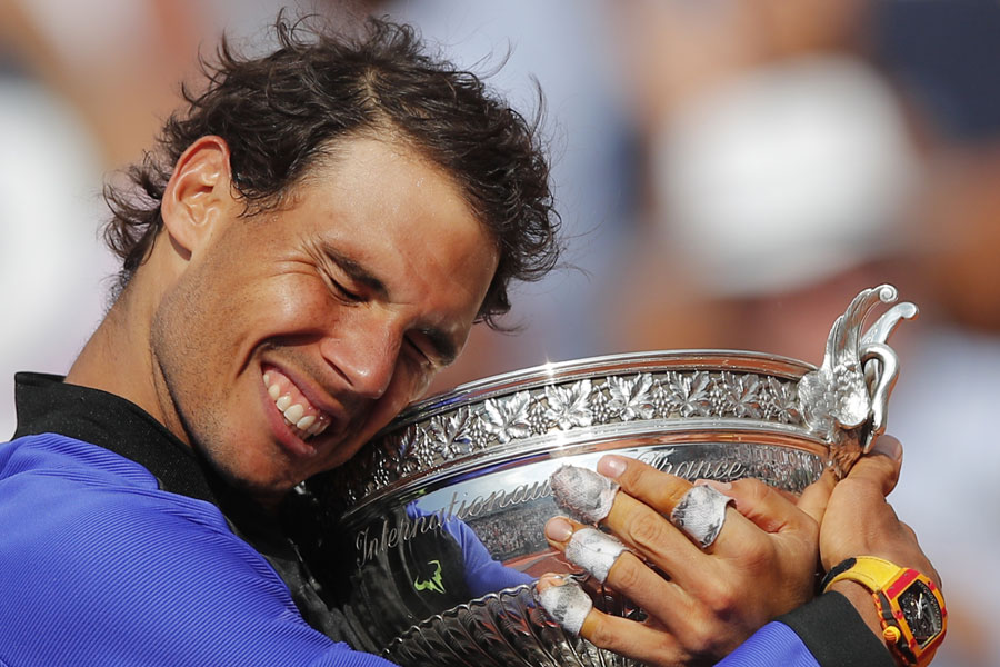 Rafael Nadal holds the trophy as he celebrates winning his tenth French Open title against Switzerland's Stan Wawrinka in three sets, 6-2, 6-3, 6-1, during their men's final match of the French Open tennis tournament at the Roland Garros stadium, in Paris, France, Sunday, June 11, 2017. [Photo: AP/Christophe Ena]