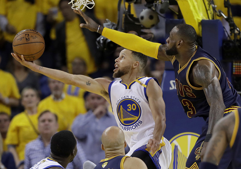 Golden State Warriors guard Stephen Curry (30) shoots against Cleveland Cavaliers forward LeBron James during the second half of Game 1 of basketball's NBA Finals in Oakland, Calif., Thursday, June 1, 2017. [Photo: AP /Marcio Jose Sanchez]