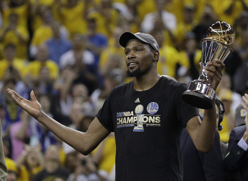 Golden State Warriors forward Kevin Durant gestures as he holds the Bill Russell NBA Finals Most Valuable Player Award after Game 5 of basketball's NBA Finals between the Warriors and the Cleveland Cavaliers in Oakland, Calif., Monday, June 12, 2017. The Warriors won 129-120 to win the NBA championship. [Photo: AP /Marcio Jose Sanchez]