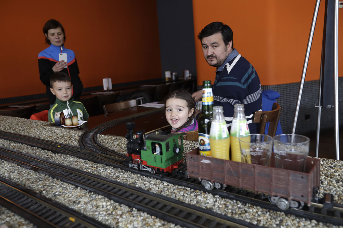 A model freight train carries beverages to costumers in a restaurant in Prague, Czech Republic, Wednesday, April 19, 2017. In three Czech restaurants, model freight trains arrive at your table and stop right in front of you with your your order of drinks. The only thing you have to do is to pick up your glass before the train departs. It’s reasonably fast, efficient and fun. [Photo: AP/Petr David Josek]