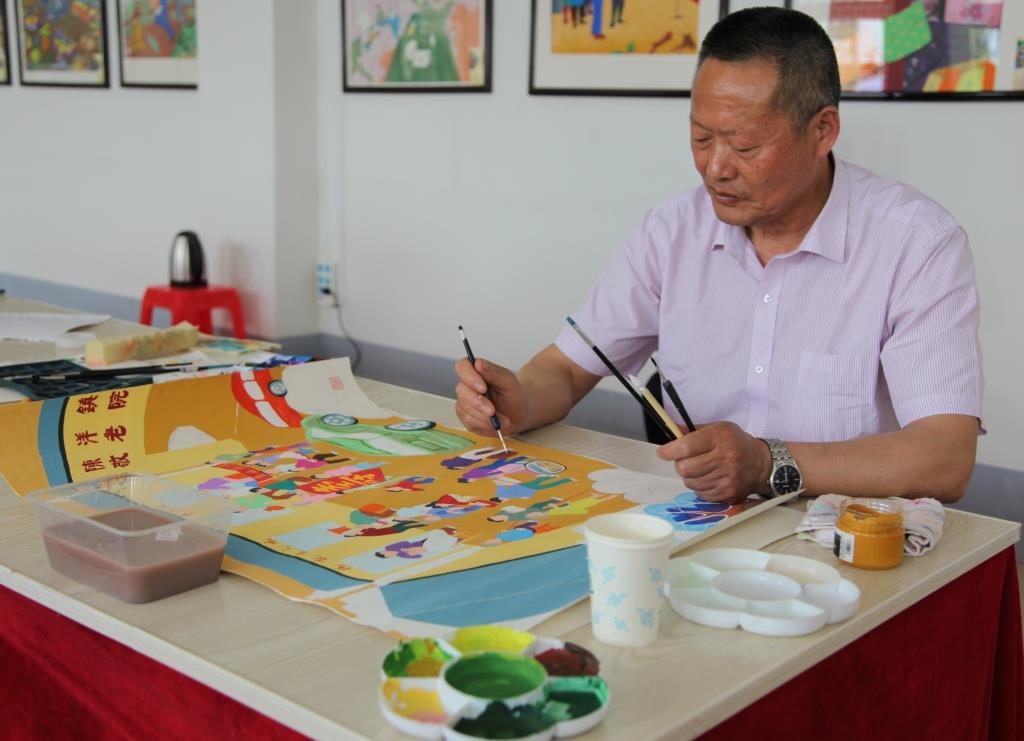 Zhang Guorong, 63, a retired rural primary school art teacher, works part time for the Sheyang Farmers Painting Institute. [Photo: Chinaplus/Yin Xiuqi]