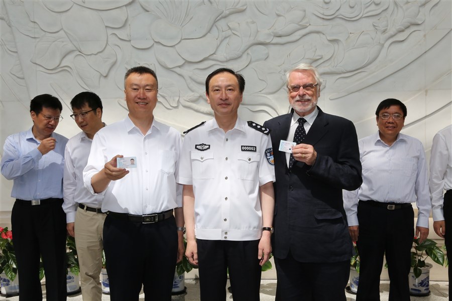 Chen Zhen (center), vice head of Shanghai Public Security Bureau, poses with Anders Lindquist (right), a professor at Shanghai Jiao Tong University, and Li Dongsheng (left), a deputy director of Shanghai Aircraft Design and Research Institute, today at a card-giving ceremony. [Photo: Shanghai Daily/Ti Gong]