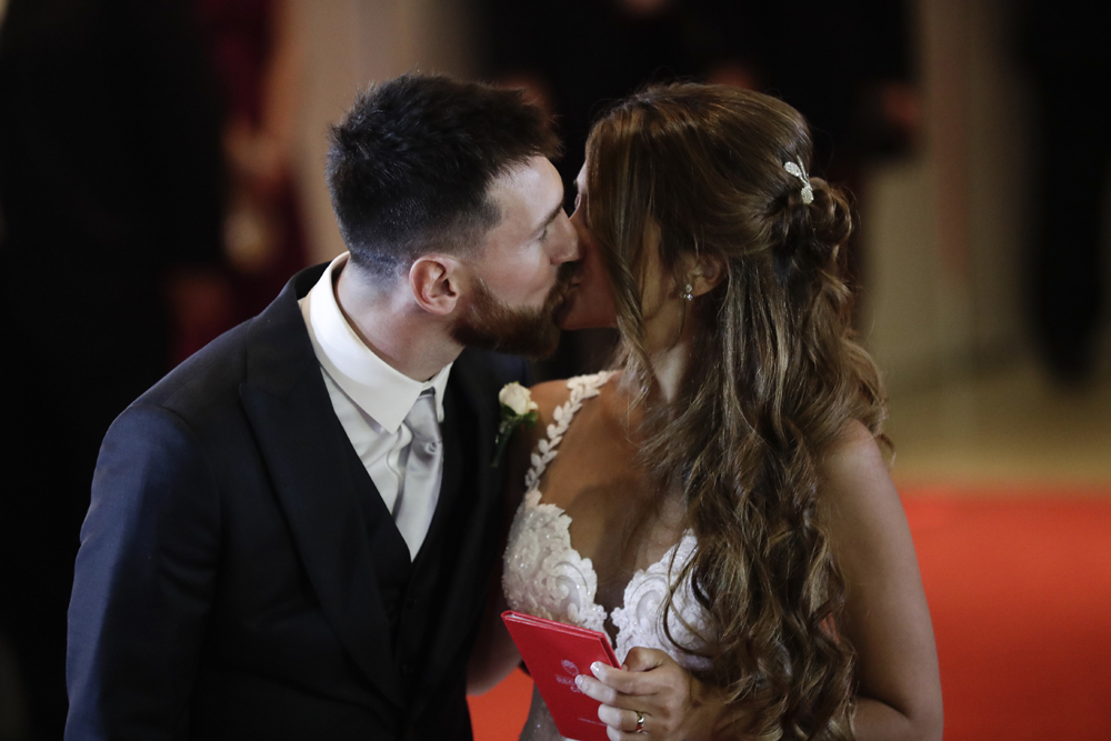 Newlyweds Lionel Messi and Antonella Roccuzzo kiss while posing for photographers on the red carpet after tying the knot in Rosario, Argentina, Friday, June 30, 2017. About 250 guests, including teammates and former teammates of the Barcelona star, attended the highly anticipated ceremony. [Photo: AP/Victor R. Caivano]