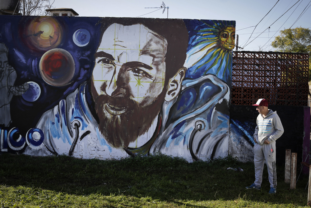 A man looks at graffiti of Lionel Messi painted near the house where the soccer star grew up in Rosario, Argentina, Friday, June 30, 2017. Some 260 guests, including teammates and former teammates of the Barcelona star, are expected to attend the highly anticipated wedding between Messi and Antonella Roccuzzo later Friday. [Photo: AP/Victor R. Caivano]