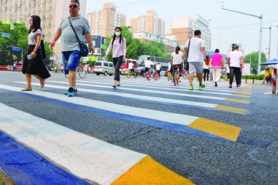 A 3D crosswalk painted in white, blue and yellow at a crossing in Beijing. [Photo: Legal Evening News]
