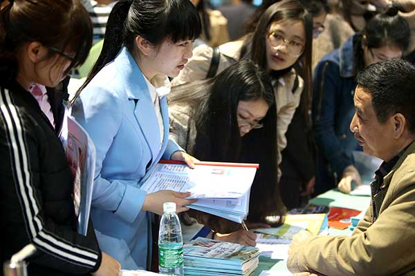 Graduates from normal universities in Hunan province interact with their potential employers at a job fair in Hengyang in March. [Photo: China Daily/Peng Bin]