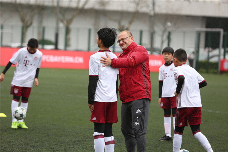 The coach from Bayern Munich trains Chinese young football players. [Photo: China Plus]