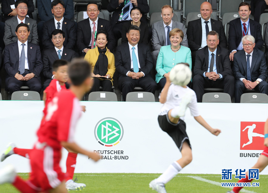 Chinese President Xi Jinping and German Chancellor Angela Merkel watch a football match between Chinese and German youth teams on Wednesday. [Photo: Xinhua]