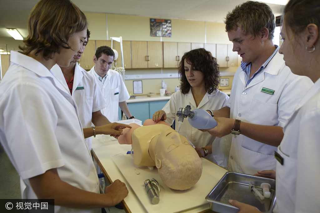 Medical students practice CPR on a dummy. [Photo: VCG]