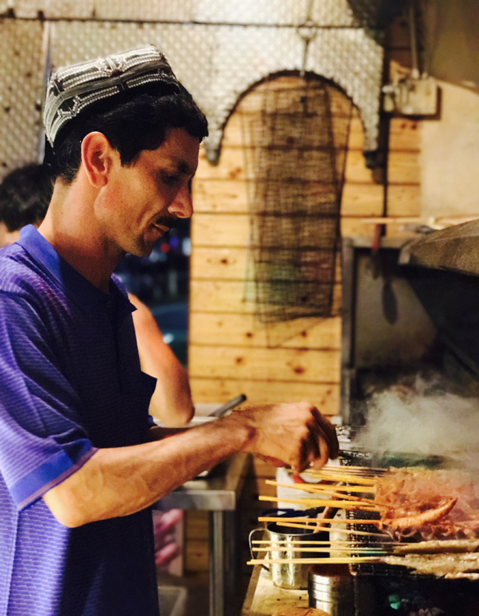 Abdulla is preparing barbecue in the kitchen of his own restaurant. [Photo: China Plus]