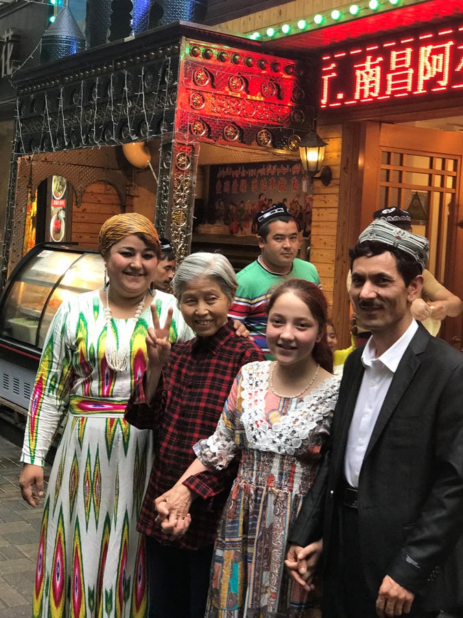 Abdulla Ulaxim, Abdulla's wife and their daughter with their friend in front of Abdulla's restaurant [Photo: China Plus]